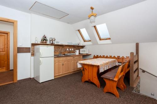a kitchen with a table and a white refrigerator at Penzión Soňa in Ždiar