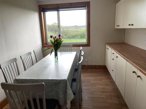 een keuken met een tafel met een vaas met bloemen erop bij Galloway Farmstay Broughton in Newton Stewart