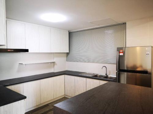 una cocina con fregadero y refrigerador en Rohani Jazz Suites 4 @ Vivacity Megamall, en Kuching