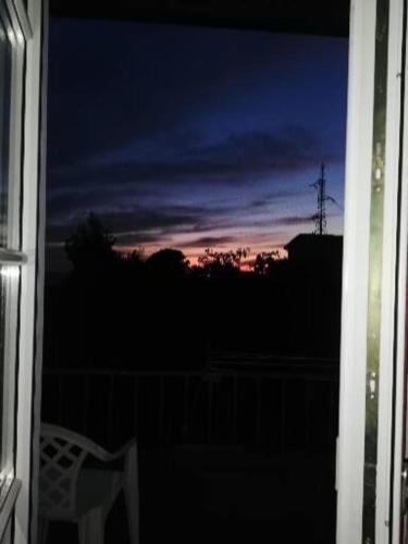 a view of a sunset from a window with a chair at Ca' Clémentine in Sasso di Bordighera