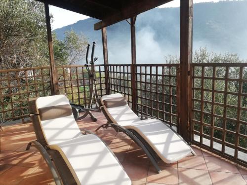 eine Veranda mit Stühlen und Bergblick in der Unterkunft Ca' Clémentine in Sasso di Bordighera