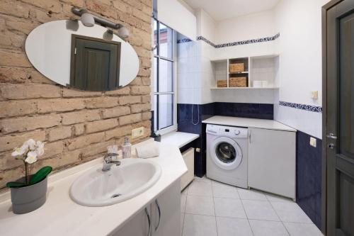 a bathroom with a sink and a washing machine at Old Riga Aldaru Street Historic One Bedroom Apartment in Riga