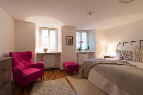 a bedroom with a bed and a red chair at Burgblickhotel in Bernkastel-Kues