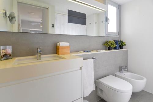 une salle de bain avec toilettes, lavabo et miroir dans l'établissement CANAMI... Luxury apartment with best sea views., à Colonia Sant Jordi
