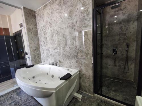 a bathroom with a large tub and a shower at The Golden Pera's Hotel & Spa in Istanbul