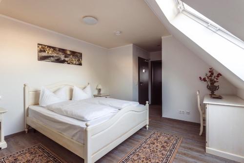 a bedroom with a white bed and a staircase at Hotel Roma in Kehl am Rhein