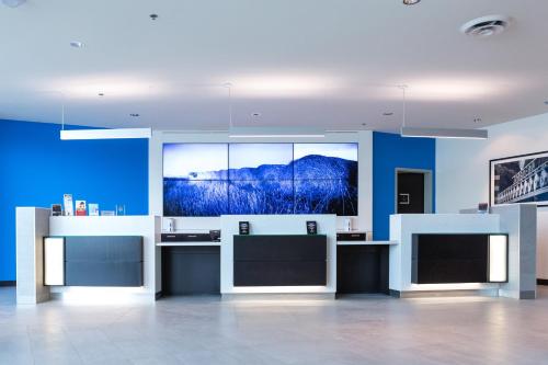 a room with blue walls and a tv on the wall at The Grand Winnipeg Airport Hotel by Lakeview in Winnipeg