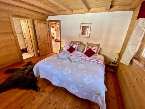 a bedroom with a bed in a log cabin at Le Mélézin Bleu in Morgins