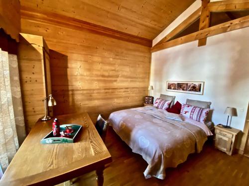 a bedroom with a bed and a wooden wall at Le Mélézin Bleu in Morgins