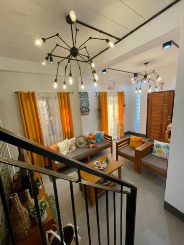 a living room with couches and a chandelier at REEF HOUSE BACNOTAN White sand beach front with Private Swimming pool in Bacnotan