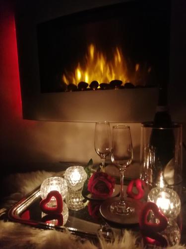 a table with two wine glasses and a fireplace at Il cielo in una stanza in Itri