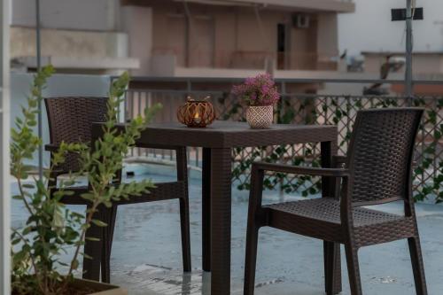 a table with two chairs and a bowl of flowers on it at P&K LUXURY APARTMENTS 3 in Kalamata