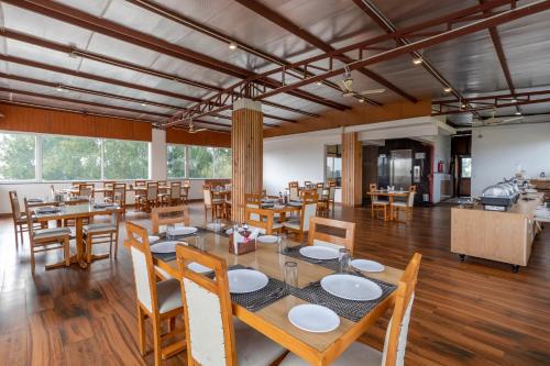 a dining room with wooden tables and chairs at Hotel White Rock By The Solitaire Hospitality in Dehradun