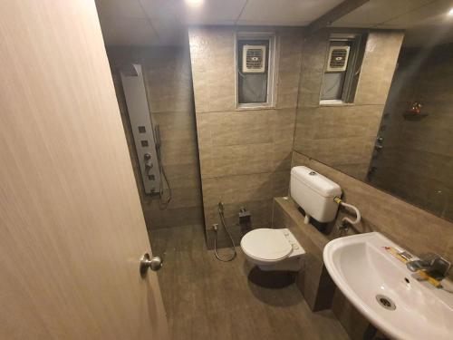 une salle de bain avec toilettes et lavabo dans l'établissement Weekend Address Managed By P.C Homes, à Surate