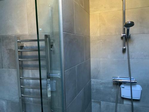 a shower with a glass door in a bathroom at Chater Cottage Rothbury in Rothbury