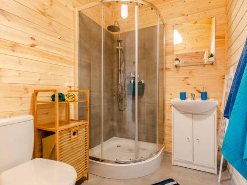 a bathroom with a shower and a toilet and a sink at Domki Letniskowe Słoneczna Przystań in Ustka