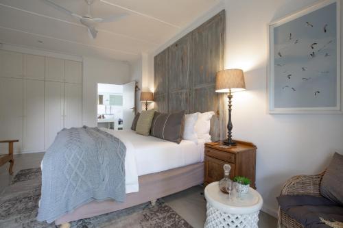 a bedroom with a bed and a couch at Long Story Guest House in Plettenberg Bay