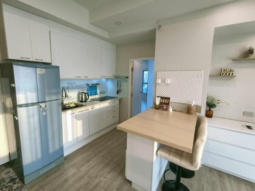 La cuisine est équipée de placards blancs et d'un réfrigérateur bleu. dans l'établissement Harmony family room, à Bangkok