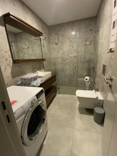 Residence Retro9 B-Blok Ataköy Apart 2 Rooms WIFI Pool Istanbul في إسطنبول: حمام مع غسالة ومغسلة