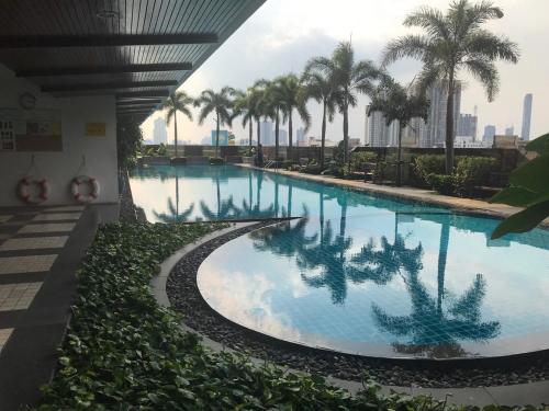 - une grande piscine avec des palmiers dans un bâtiment dans l'établissement Harmony family room, à Bangkok
