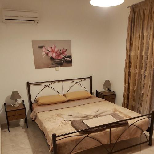 a bedroom with a bed with two night stands and two lamps at ANTONIOS apartments in Archangelos