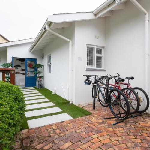 a group of bikes parked on the side of a house at Long Story Guest House in Plettenberg Bay