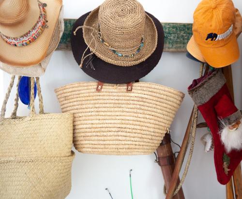 a group of straw hats hanging on a wall at Long Story Guest House in Plettenberg Bay