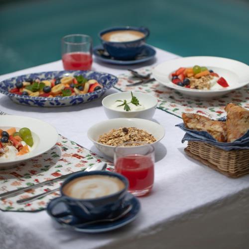 a table with plates of food and bowls of food at Long Story Guest House in Plettenberg Bay