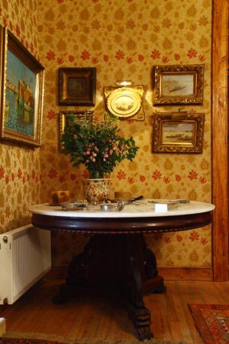 a room with a table with a clock on the wall at Hacienda los Lingues Chile Valle de Colchagua in Los Lingues