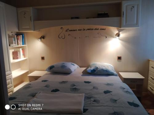a bedroom with a bed with a sign on the wall at La maison des loirs in Valréas