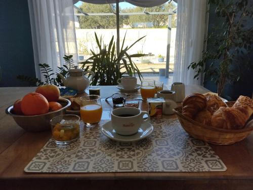 une table avec un petit-déjeuner composé de pain et de jus d'orange dans l'établissement Almendra34480, à Magalas