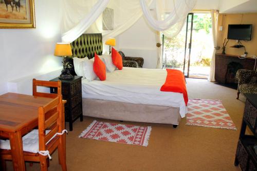 Un pat sau paturi într-o cameră la Hartbeespoortdam Lodge