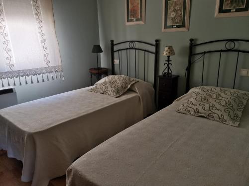 Dos camas una al lado de la otra en un dormitorio. en Ático en pleno centro de Baiona con garaje, en Baiona