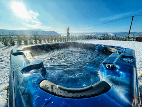 a jacuzzi tub in the snow with the sun in the background at Csigevár Birtok in Balatonendréd