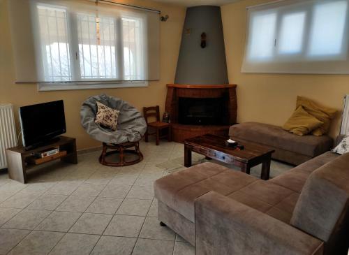 ein Wohnzimmer mit einem Sofa und einem TV in der Unterkunft POLYTIMI HOUSE in Kalavryta