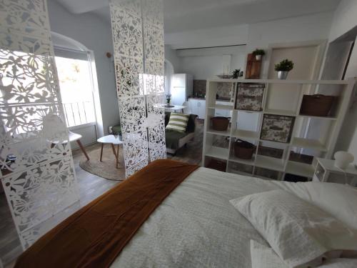 1 dormitorio con 1 cama grande y sala de estar en Casa El Picacho en Alcalá de los Gazules