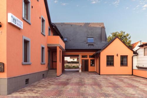 an orange building with a driveway in front of it at Hotel Roma in Kehl am Rhein