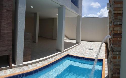 una piscina con una fuente de agua en una casa en Apto inteiro Seguro e Confortável com piscina, en Anápolis