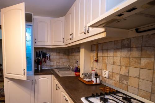 a kitchen with white cabinets and a counter top at Stella's cozy home in Baloteşti