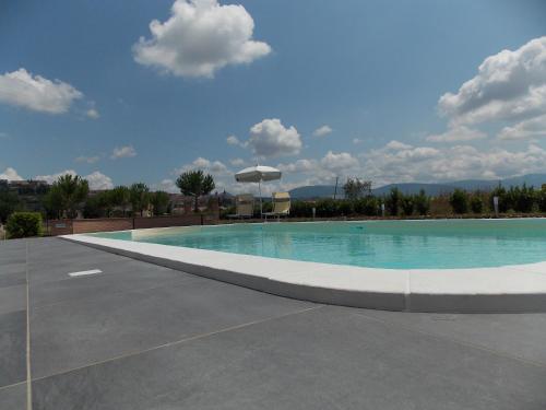 a large swimming pool in a parking lot at Residence Terra Dei Santi Country House in Spello
