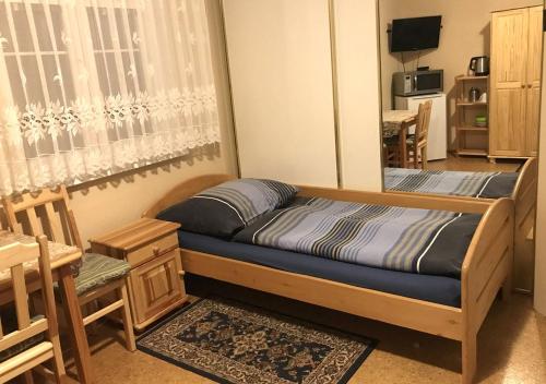 ムラダー・ボレスラフにあるModrý Pensionのベッドルーム1室(ベッド1台、テーブル、椅子付)