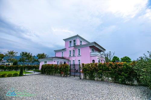 a pink house with a fence in front of it at 獨棟別墅 私人花園 桐話親子民宿 Tonghua B&B in Guilin