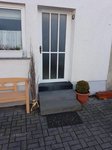 a front door of a house with a bench at Ferienwohnung Schacht in Longkamp