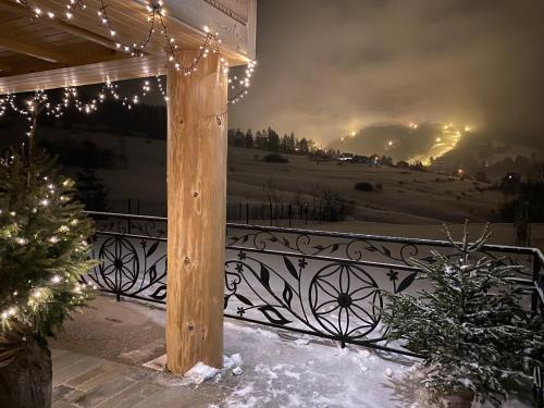 a wooden pergola with christmas lights on a fence at Osada Snozka in Kluszkowce