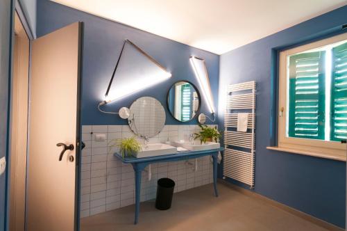 a blue bathroom with a sink and a mirror at Gabanel Bike Hostel in Bussolengo