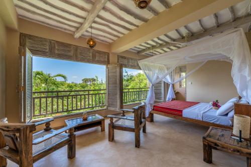 a bedroom with a bed and a balcony at Tombo House in Diani Beach