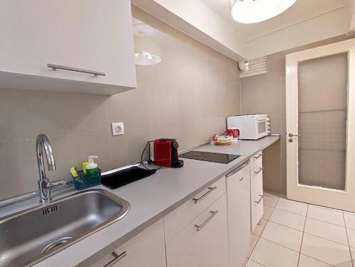 a kitchen with a sink and a microwave at Avli apartment in Athens