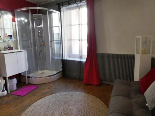 La salle de bains est pourvue d'une douche et d'un canapé. dans l'établissement Au Mange-Prunes, à Auzon