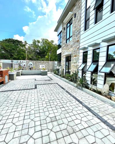 a brick building with a patio with a bench at REEF HOUSE BACNOTAN White sand beach front with Private Swimming pool in Bacnotan