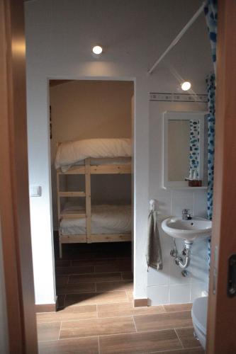 een badkamer met een stapelbed en een wastafel bij Quarto Santo António in Zambujeira do Mar